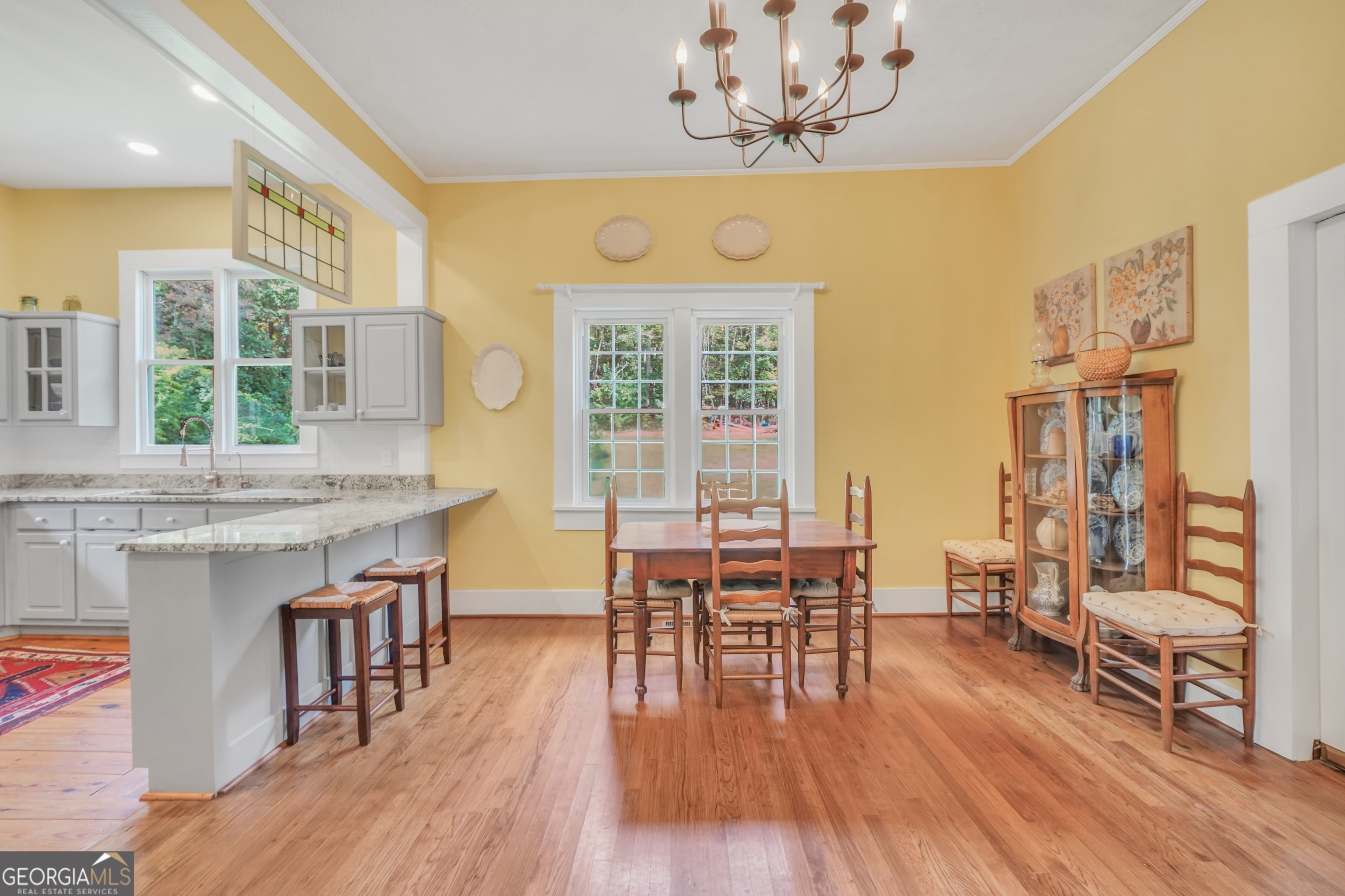 686 Burkett Road Thomaston, GA 30286 - Photo 14 of 70 a dining room with wooden floor a chandelier a wooden table and chairs