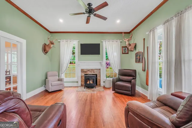 a dining room with wooden floor a chandelier a wooden table and chairs