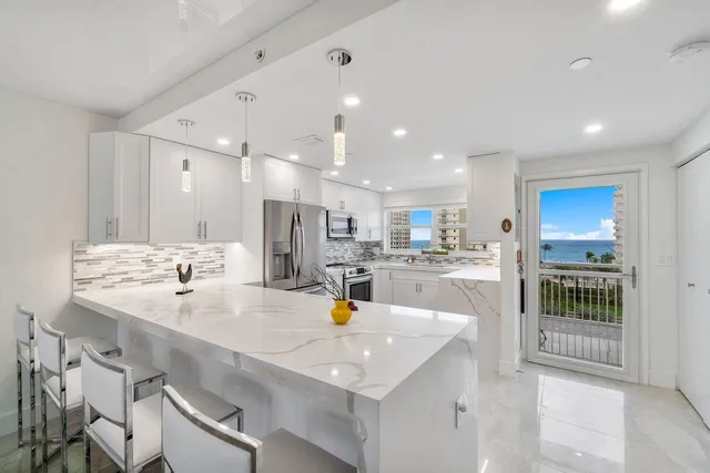 a kitchen with a sink stainless steel appliances and white cabinets