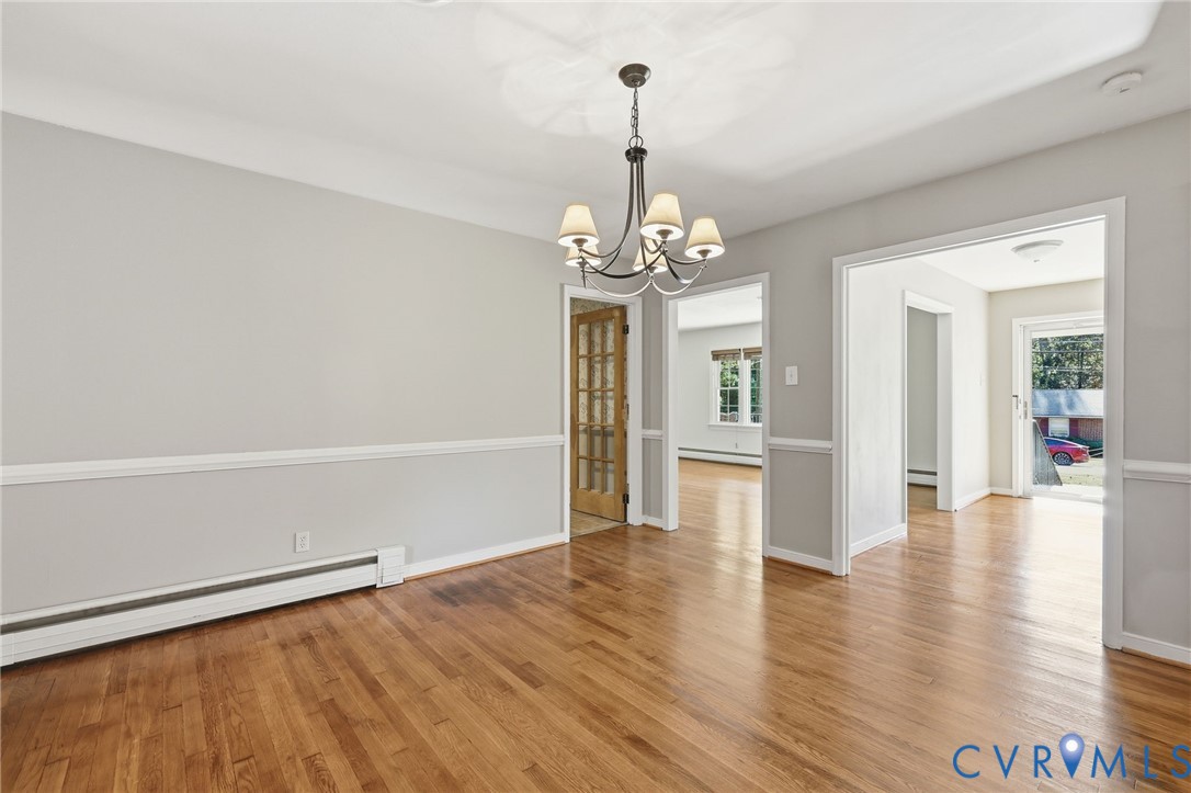 12673 Winfree Street Chester, VA 23831 - Photo 21 of 31 a view of a hallway with wooden floor and a chandelier