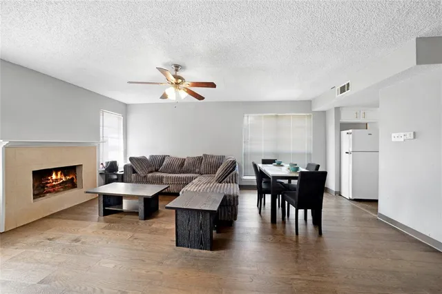 a living room with furniture a fireplace and a ceiling fan