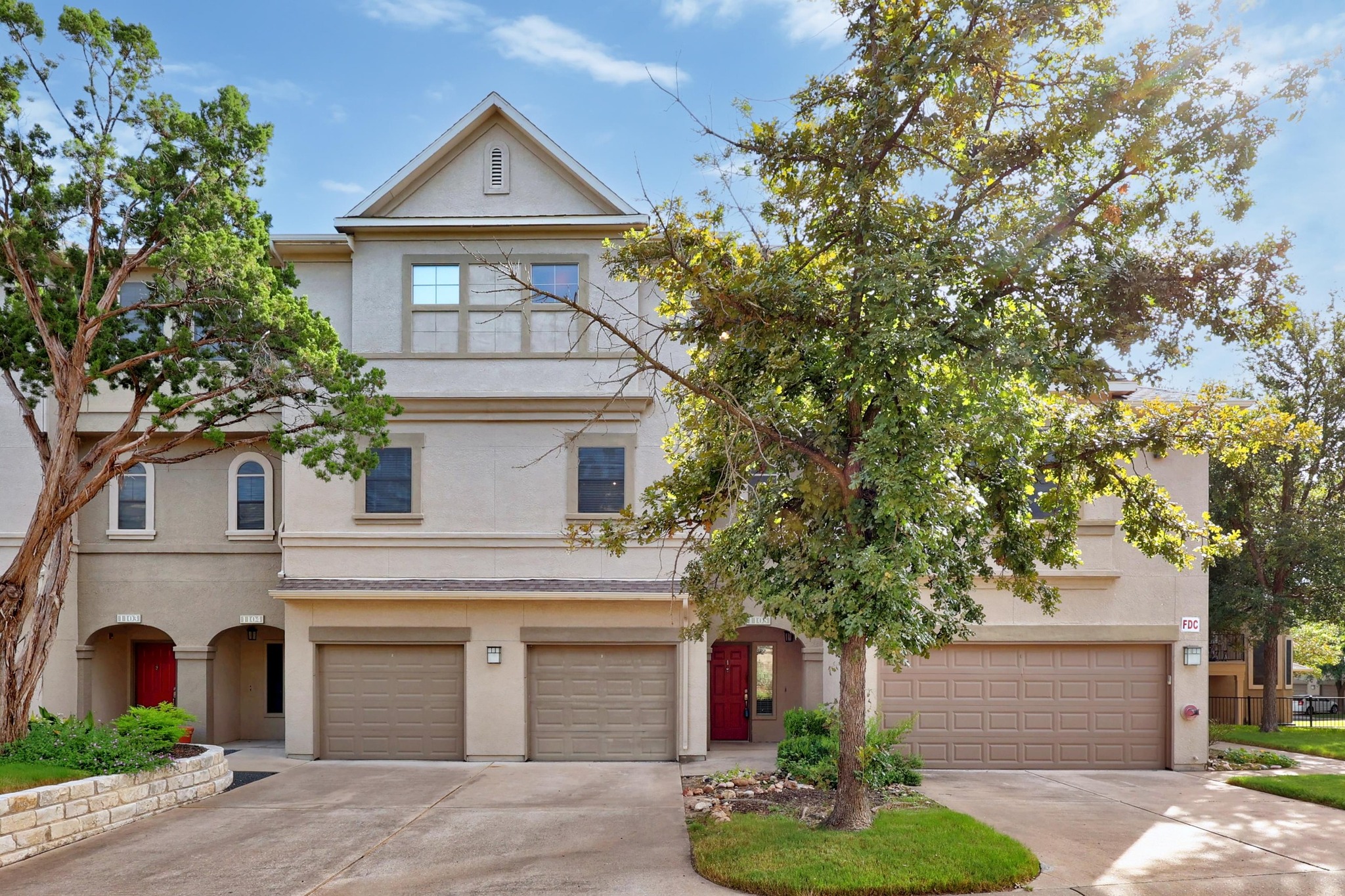 View of front of house with stucco siding, driveway, and an attached garage