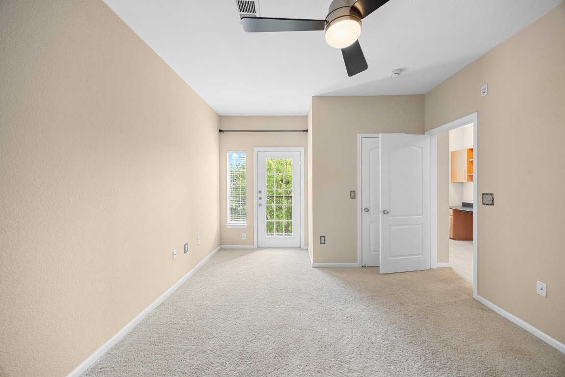 11203 Ranch Road 2222, Unit 1105 Austin, TX 78730 - Photo 13 of 35 an empty room with chandelier fan and windows