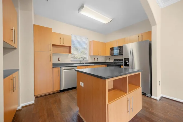a kitchen with stainless steel appliances granite countertop a refrigerator a sink and a stove