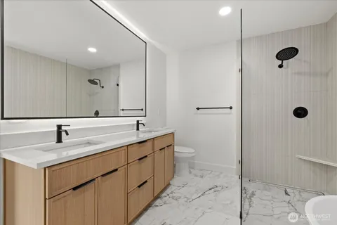 a bathroom with a granite countertop sink mirror and toilet