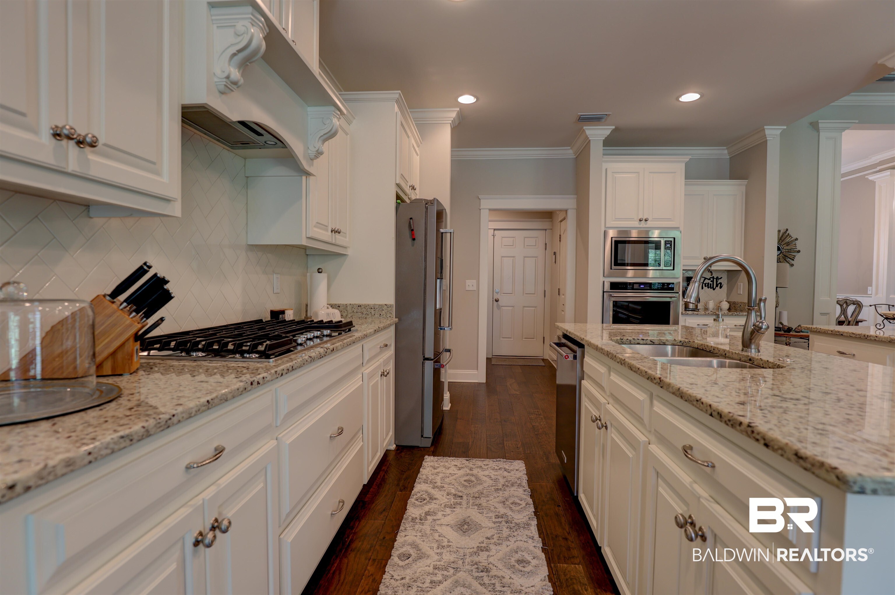 10588 Leesburg Pike Daphne, AL 36526 - Photo 12 of 29 Kitchen with tasteful backsplash, crown molding, custom range hood, appliances with stainless steel finishes, and dark wood-type flooring