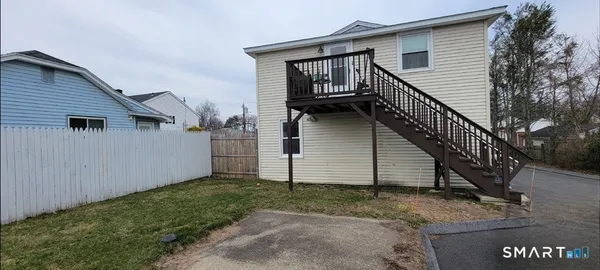 a view of a house with backyard and trees