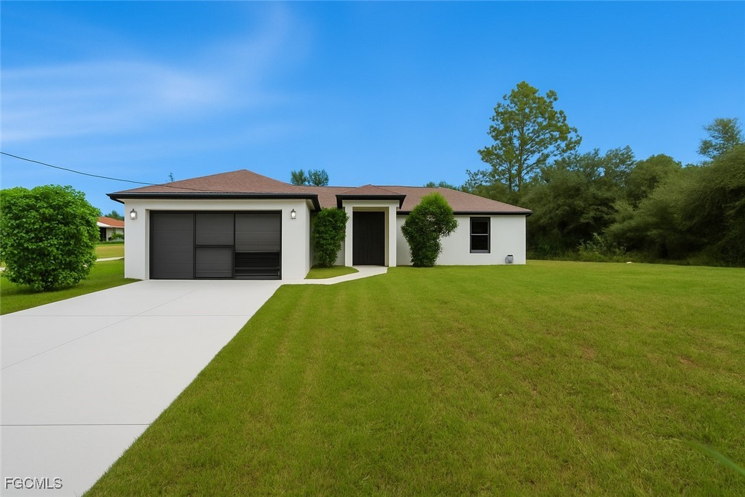 2701 East 18th Street Lehigh Acres, FL 33972 - Photo 1 of 24 a front view of a house with a garden