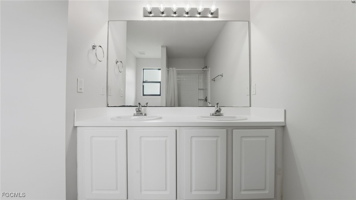 2701 East 18th Street Lehigh Acres, FL 33972 - Photo 12 of 24 a bathroom with a granite countertop sink and a mirror