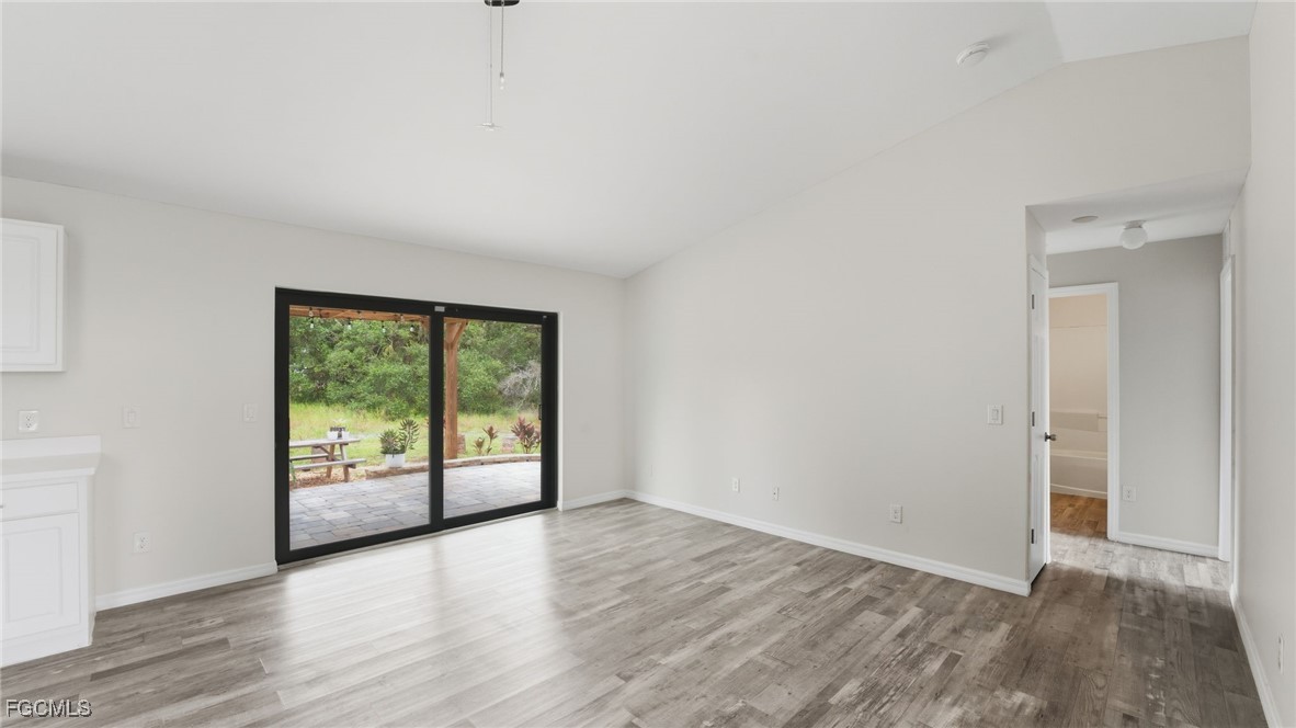 2701 East 18th Street Lehigh Acres, FL 33972 - Photo 8 of 24 an empty room with wooden floor and windows