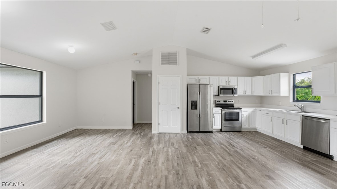2701 East 18th Street Lehigh Acres, FL 33972 - Photo 9 of 24 a kitchen with stainless steel appliances a refrigerator and a stove top oven