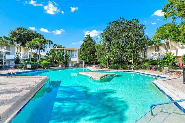 an aerial view of city and lake with trees all around