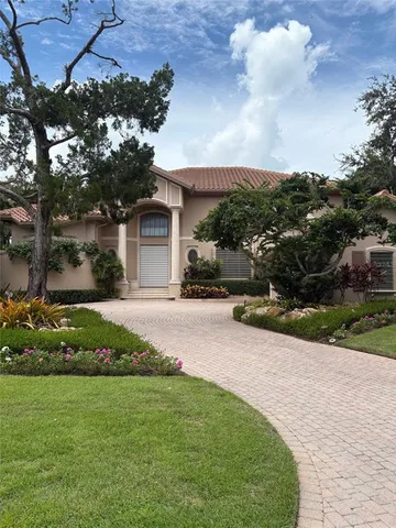 a front view of a house with a garden and a yard