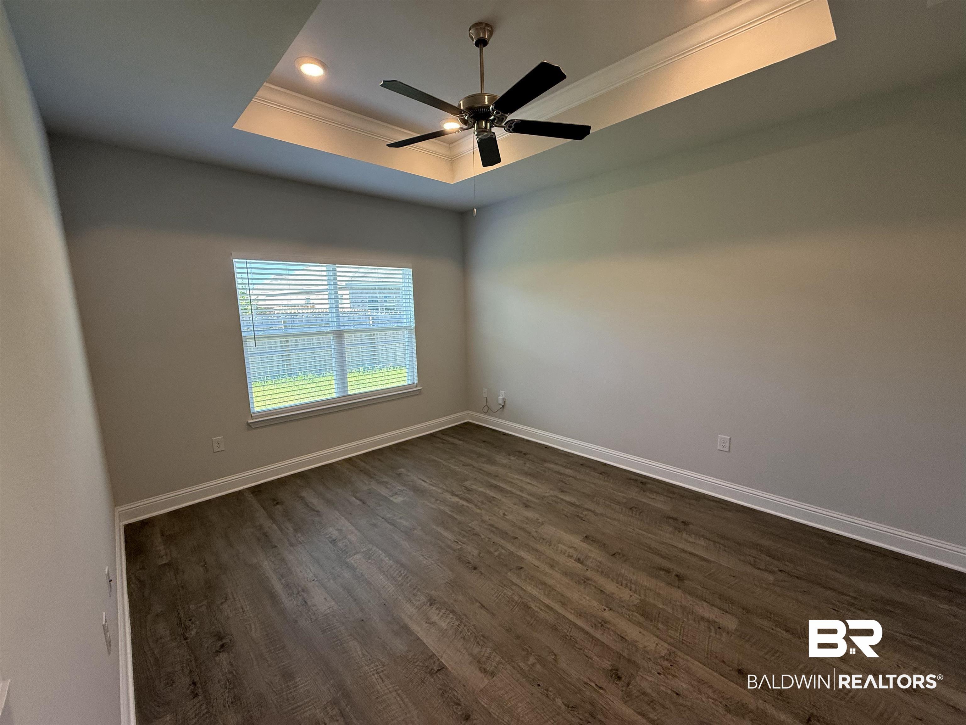 23247 Lieutenant Avenue Foley, AL 36535 - Photo 28 of 47 Spacious room featuring wood-finish flooring, light gray walls, and a tray ceiling with recessed lighting