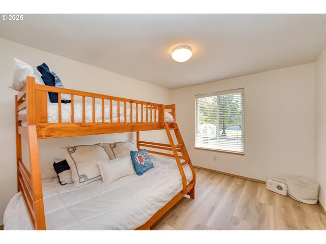a bedroom with a bed and wooden floor
