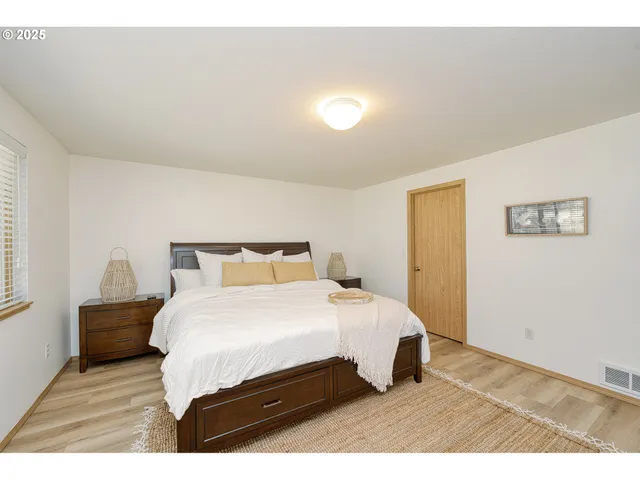 a bedroom with a bed and wooden floor
