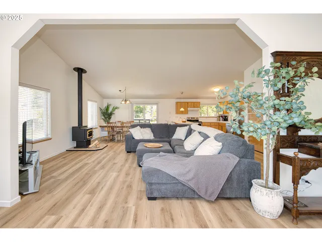 a living room with furniture wooden floor and a large window