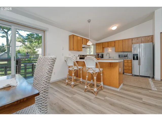 a living room with stainless steel appliances kitchen island granite countertop furniture and a large window