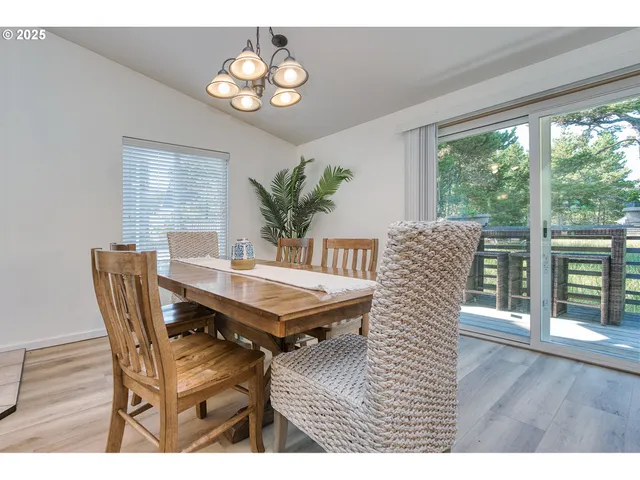 a dining room with furniture a large window and wooden floor