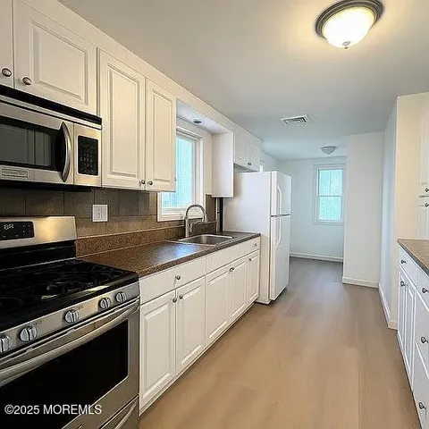 a kitchen with stainless steel appliances granite countertop a stove a sink and a refrigerator