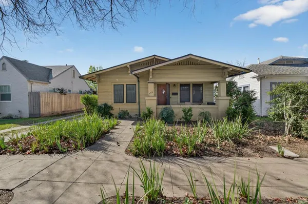 a front view of a house with a yard and potted plants