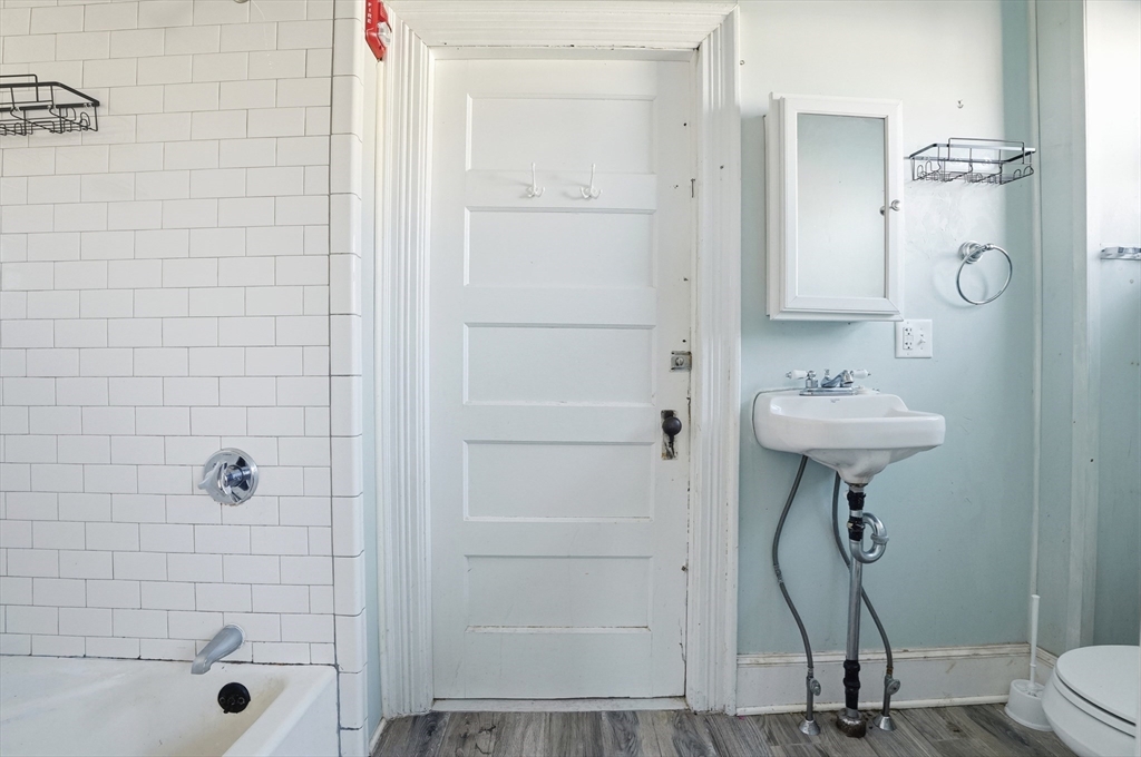 621 2nd Street Fall River, MA 02721 - Photo 13 of 42 a bathroom with a sink a mirror a glass door a shower and a mirror