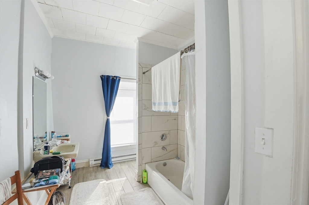 621 2nd Street Fall River, MA 02721 - Photo 15 of 42 a bathroom with a bathtub a sink and a window