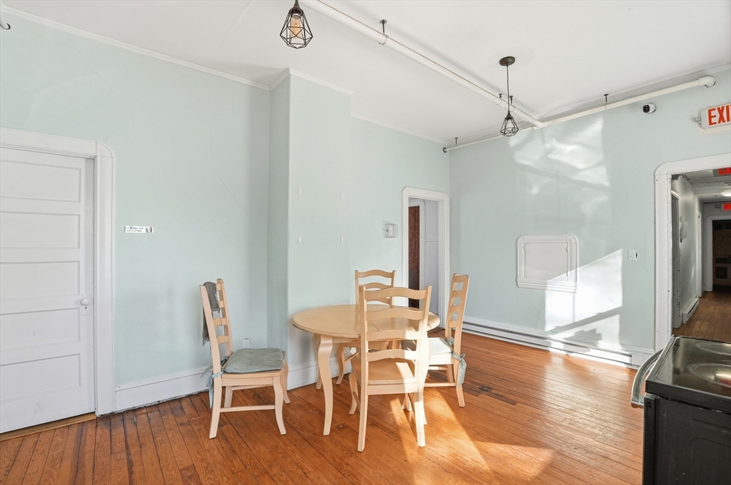 621 2nd Street Fall River, MA 02721 - Photo 24 of 42 a dining room with wooden floor a chandelier a glass table and chairs