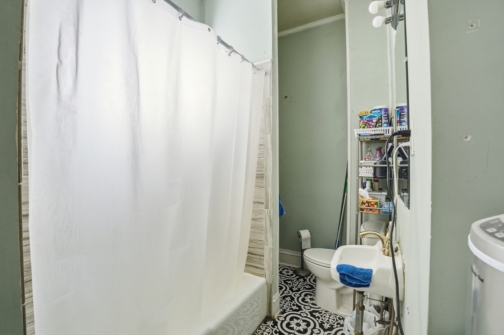621 2nd Street Fall River, MA 02721 - Photo 40 of 42 a bathroom with a shower curtain and a sink