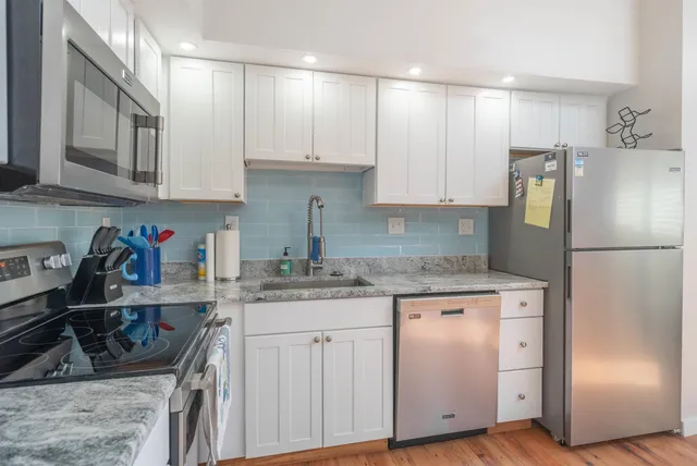 a kitchen with stainless steel appliances granite countertop a refrigerator sink and cabinets