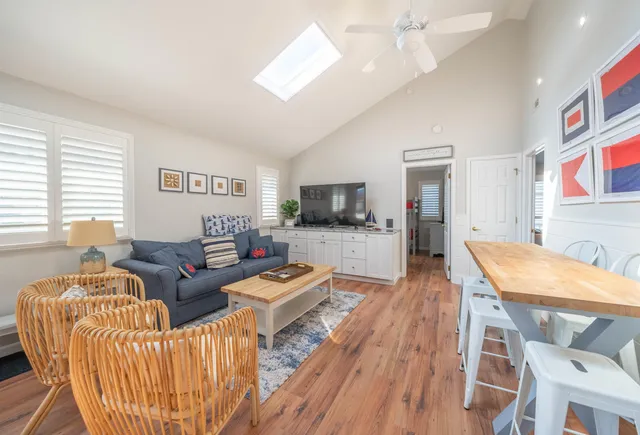 a living room with furniture a flat screen tv and kitchen view