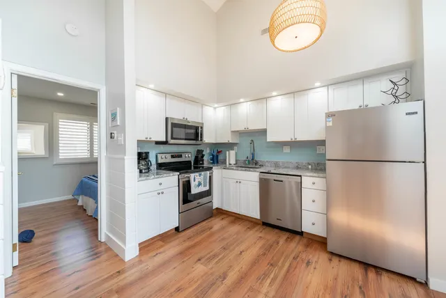 a kitchen with a refrigerator cabinets and wooden floor