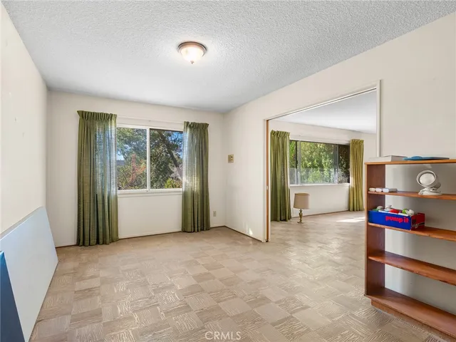 a view of an empty room with a window and television