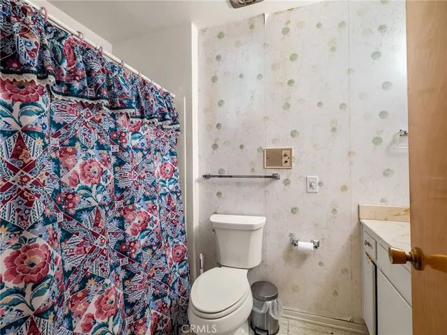a bathroom with a granite countertop sink mirror vanity and toilet