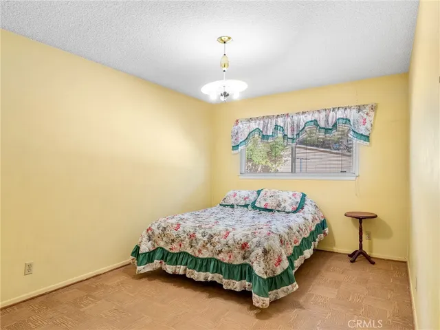 a bedroom with a bed and a chandelier