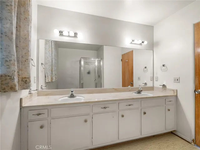 a spacious bathroom with a granite countertop sink a mirror and a shower