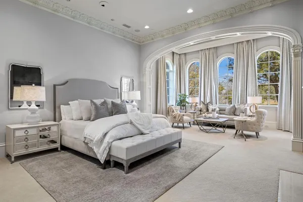 a spacious bedroom with a bed and large windows