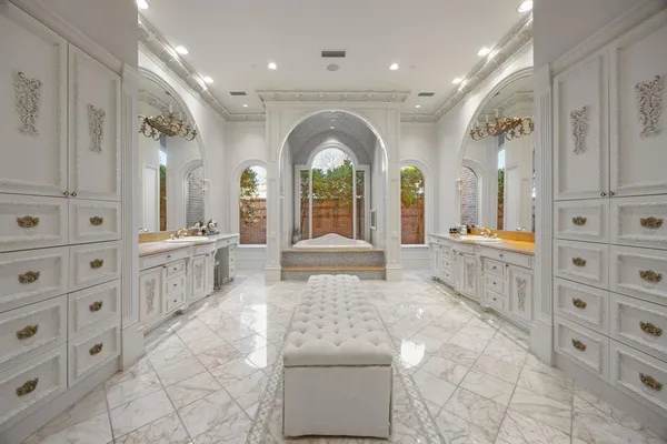 a large white bathroom with double vanity sinks a large mirror and a shower