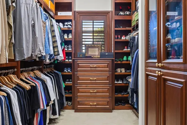 a view of walk in closet with clothes and shoes