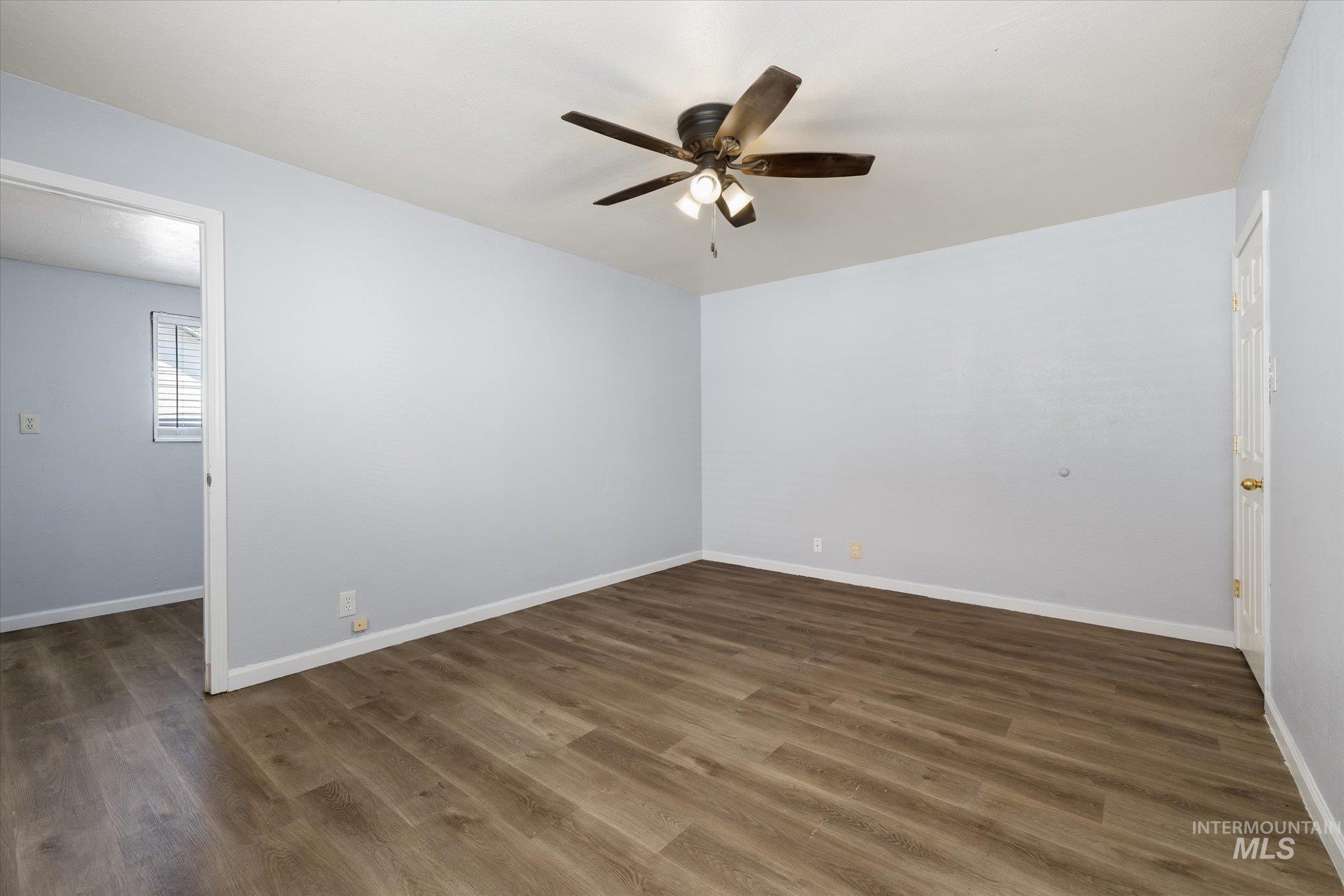 918 West 3rd Street Weiser, ID 83672 - Photo 25 of 36 Spacious room featuring wood-finish flooring, light blue walls, and a ceiling fan with integrated lighting