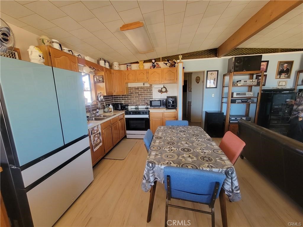5566 Oleta Road Landers, CA 92285 - Photo 6 of 21 a kitchen with stainless steel appliances granite countertop sink stove refrigerator and cabinets