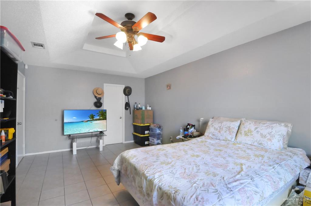 2020 Lemon Tree Court Edinburg, TX 78539 - Photo 11 of 16 a bedroom with a bed and a chandelier