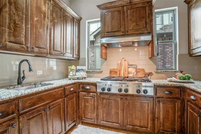 a kitchen with stainless steel appliances granite countertop a sink stove and cabinets