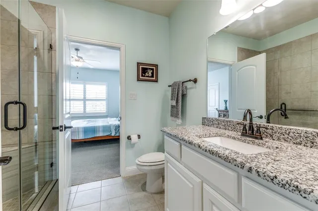 a bathroom with a granite countertop sink a toilet and a mirror