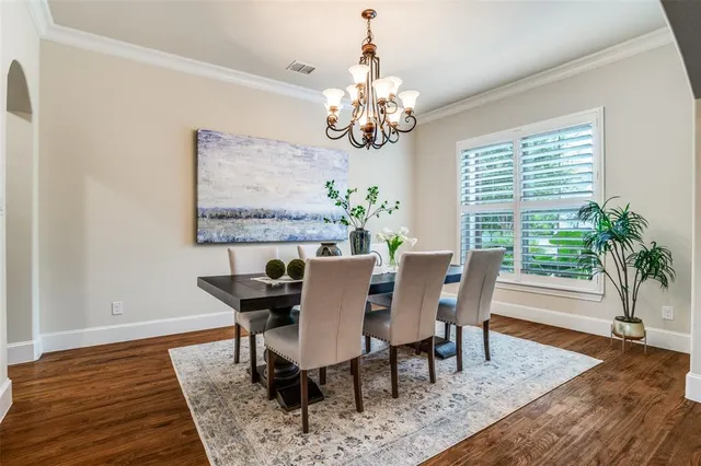 a view of a dining room with furniture a chandelier and wooden floor