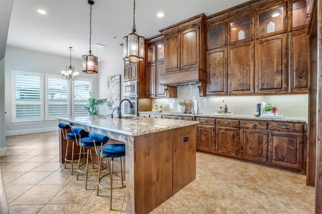 a kitchen with stainless steel appliances granite countertop wooden cabinets a dining table and chairs