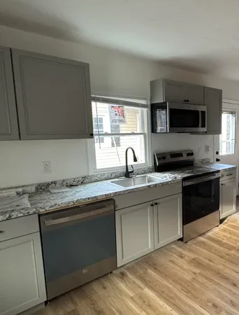 a kitchen with stainless steel appliances granite countertop a stove a sink and a microwave