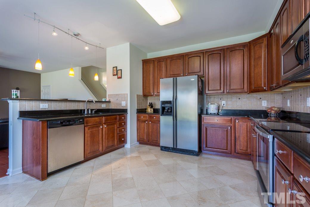4357 Karlbrook Lane Raleigh, NC 27616 - Photo 11 of 25 a large kitchen with stainless steel appliances granite countertop a stove refrigerator and a sink