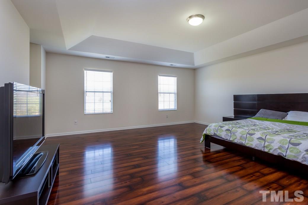 4357 Karlbrook Lane Raleigh, NC 27616 - Photo 21 of 25 a bedroom with bed and wooden floor