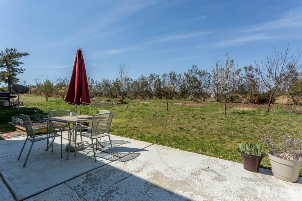 4357 Karlbrook Lane Raleigh, NC 27616 - Photo 23 of 25 a view of a lake with table and chairs potted plants and large tree
